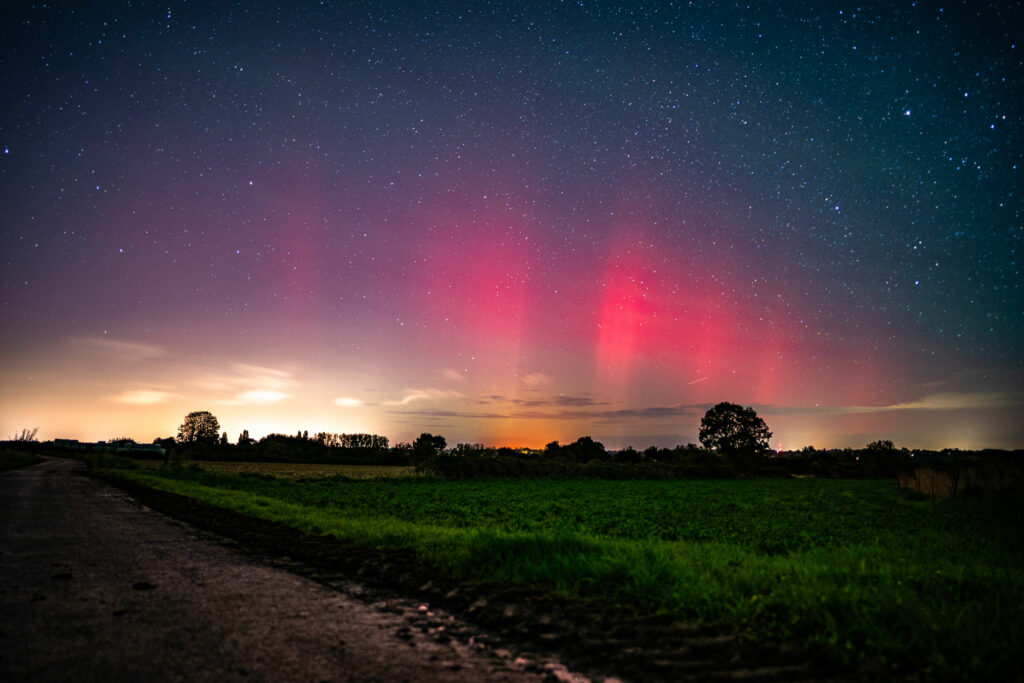 Aurore boréale rouge à Saint Suliac en Bretagne au dessus d'un champs