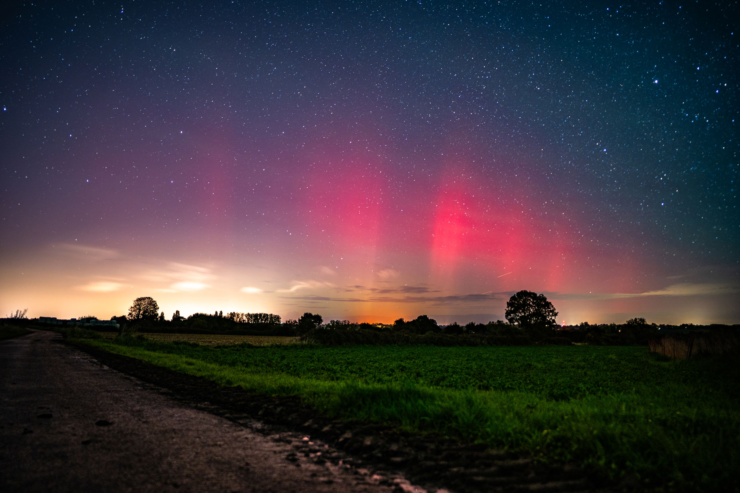 Aurore boréale rouge à Saint Suliac en Bretagne au dessus d'un champs