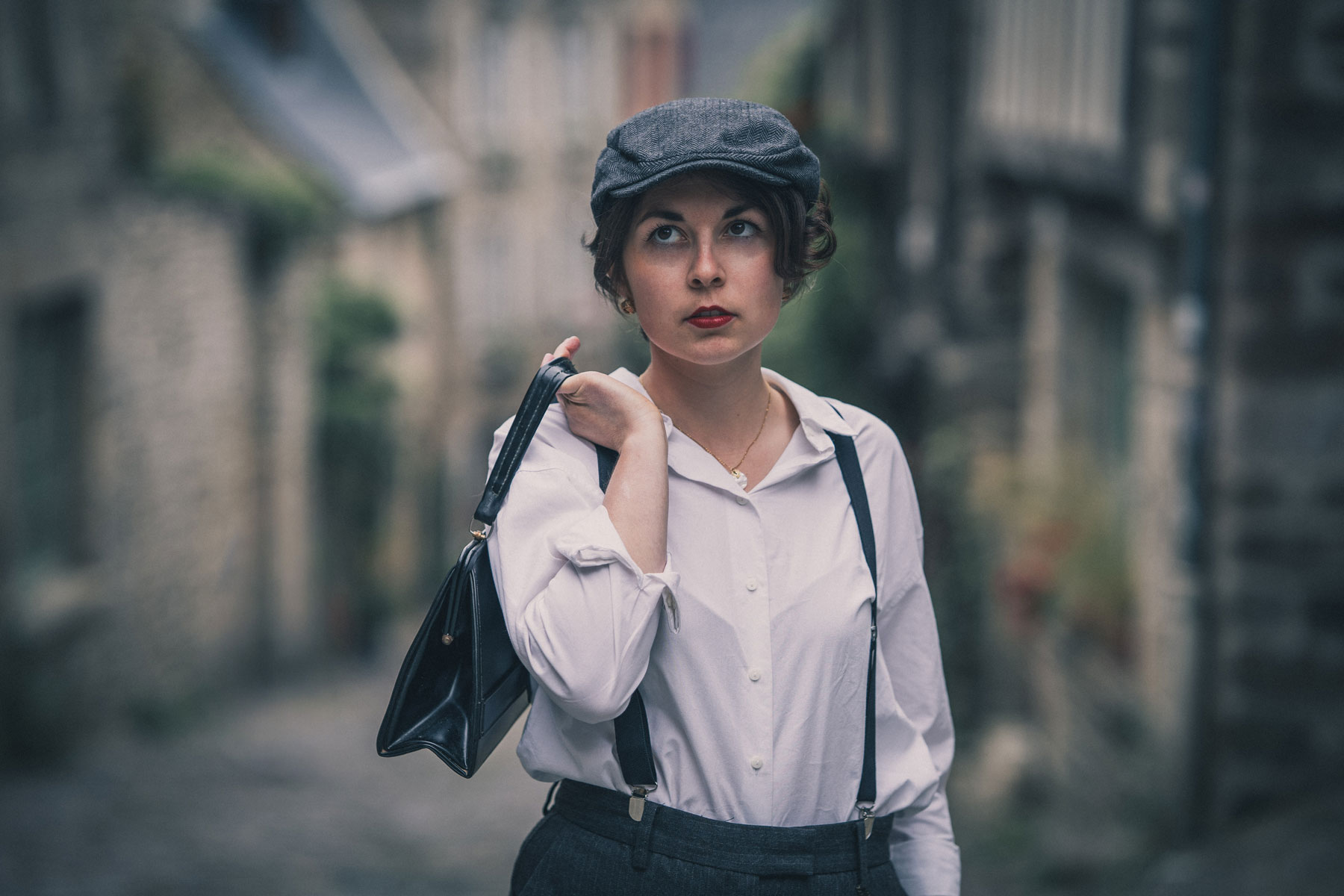 Femme en tenue des années 20 dans une ruelle de Dinan en Bretagne